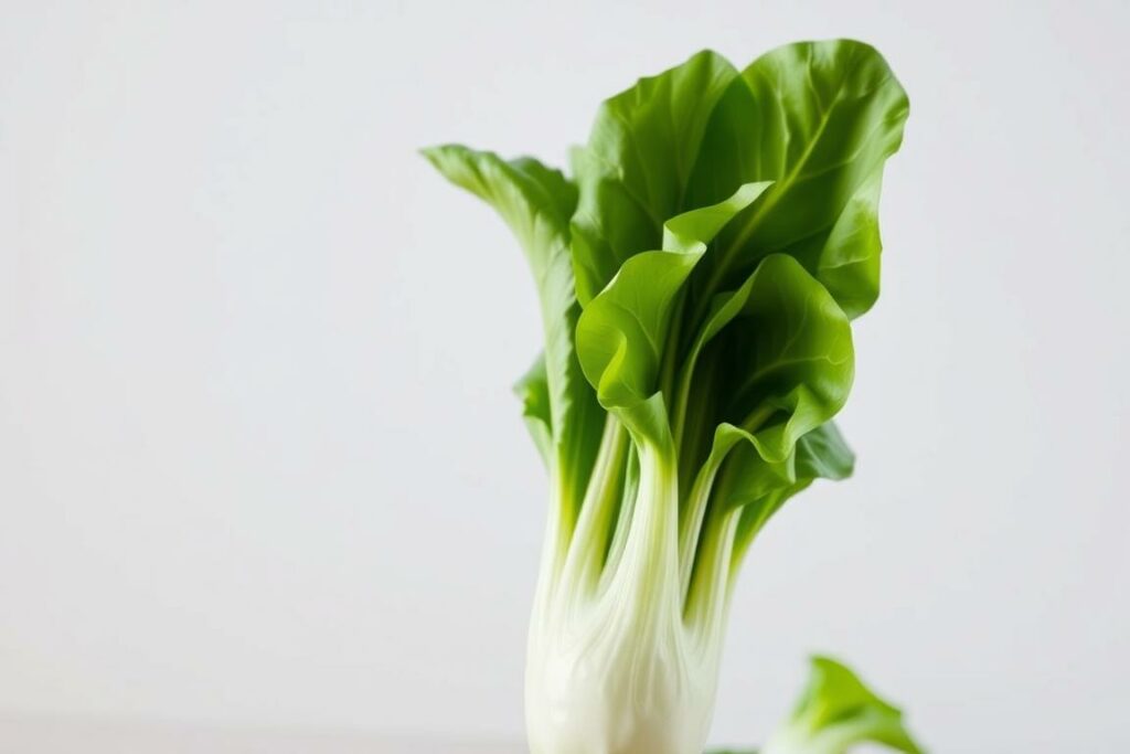 A crisp, close-up photograph of a fresh, vibrant Pak Choi vegetable in the foreground, against a clean, soft-focus background. The Pak Choi has lush, green leaves and a thick, white stem, capturing its natural beauty and texture in striking detail. The lighting is diffused and natural, creating a clean, simple, and appetizing composition. The angle is slightly angled from above, highlighting the layered leaves and the stem's cross-section. The overall mood is fresh, clean, and inviting, showcasing the key features of this versatile Asian greens in a visually compelling way.